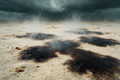 First rain hitting dry desert sand, dark wet patches spreading across pale grains under cool storm light