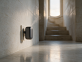 Cadence Mini plug-in diffuser in a wall socket in a pale limestone hallway at evening
